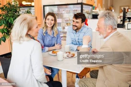 Adult children and their parents laughing together over coffee